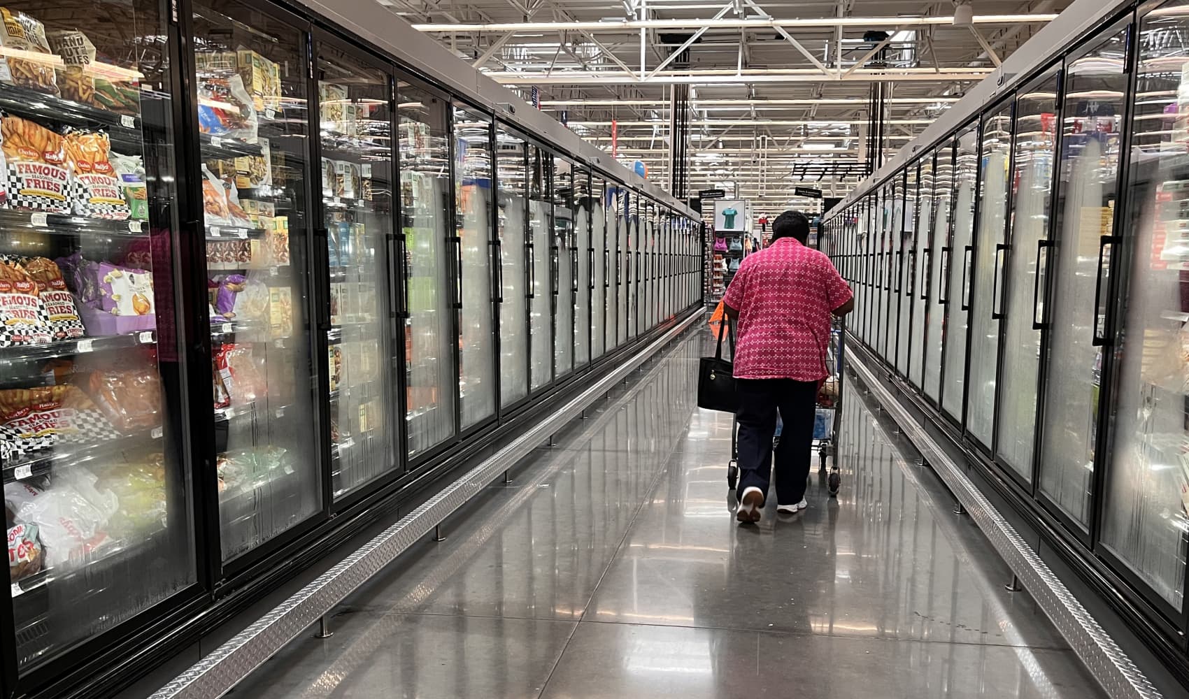 A woman walks in an aisle of a Walmart supermarket in Houston, Texas, on May 15, 2025.